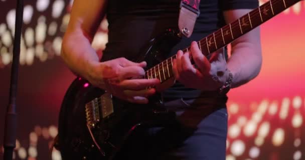 El hombre toca una guitarra eléctrica. Actuación de guitarristas en el escenario. Concierto en vivo. Primer plano, cámara lenta — Vídeos de Stock