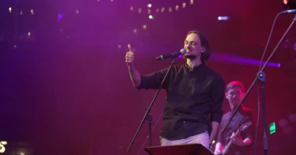 Ausdrucksstarker Sänger, der ins Mikrofon singt. Live-Musik-Konzert vor bunten Lichtern auf der Bühne. Zeitlupe — Stockvideo