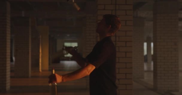 Silhouette de barman professionnel jongle bouteilles. Le barman s'entraîne dans le hall à la lumière du soleil au parking. Mouvement lent — Video