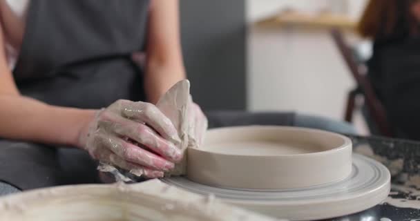 Mãos de jovem no estúdio de cerâmica usando roda de cerâmica, cerâmica artesanal, criativo. Close-up, câmera lenta — Vídeo de Stock
