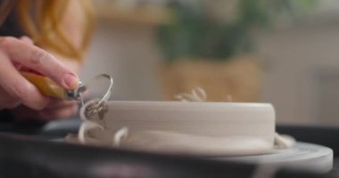 Çanak çömlek atölyesindeki bir aletle çanak sınırını şekillendirme işlemi. Bir aletle çalışan kadın çömlekçi. Yavaş çekim