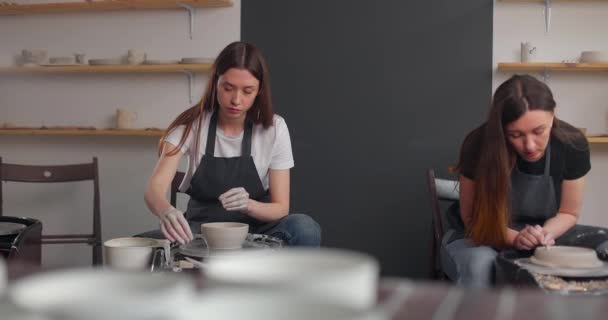 Concepto de estudio de cerámica. Dos mujeres jóvenes usando rueda de cerámica, cerámica hecha a mano, creativa. Movimiento lento — Vídeos de Stock