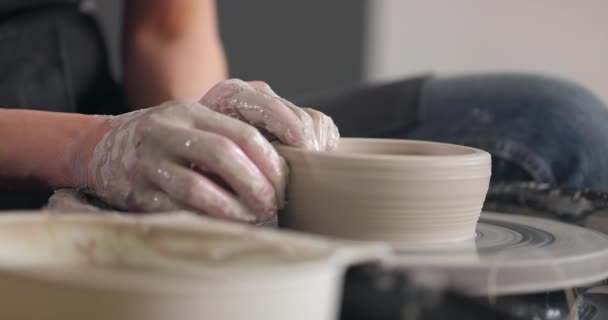 Conceito de cerâmica artesanal. Close-up de mãos de mulheres em estúdio de cerâmica. Corta a peça da roda de cerâmica. A fazer caneca. Movimento lento. — Vídeo de Stock