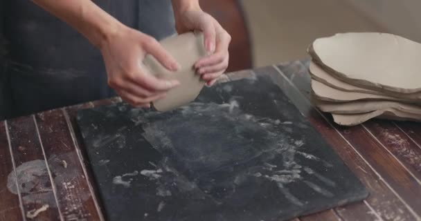 Scultore femminile impasta argilla con le mani per creare ceramica nel suo laboratorio. L'artista impasta argilla per la modellazione. Primo piano, rallentatore — Video Stock