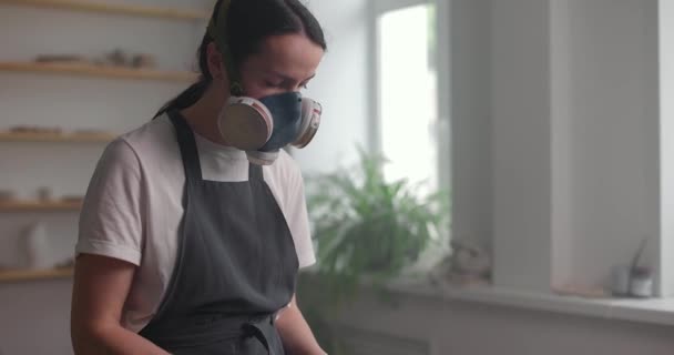 呼吸器とエプロンの女性は陶器のスタジオで釉薬を準備します。手作り陶磁器のコンセプト — ストック動画