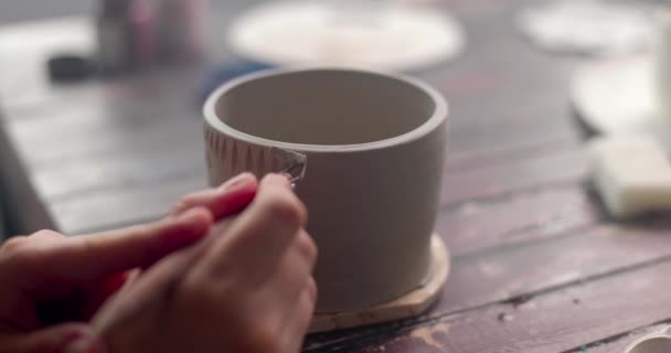 De pottenbakker versiert kleibeker met messen. Handgemaakt keramiek concept. Pottenbakkersnijwerk. Close-up, slow motion. — Stockvideo