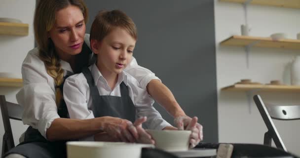 Niño y su madre en una clase magistral de cerámica. Concepto familiar feliz. Movimiento lento — Vídeos de Stock