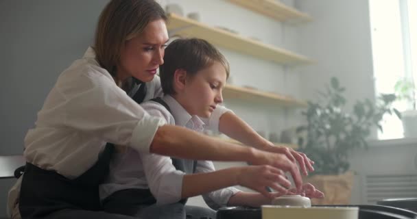 陶器師のクラスで働いている子供の男の子と彼の母親のサイドショット。幸せな家族の概念。スローモーション — ストック動画