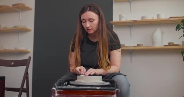 Jeune femme en atelier de poterie utilisant roue de poterie, céramique artisanale, créatif. Mouvement lent — Video