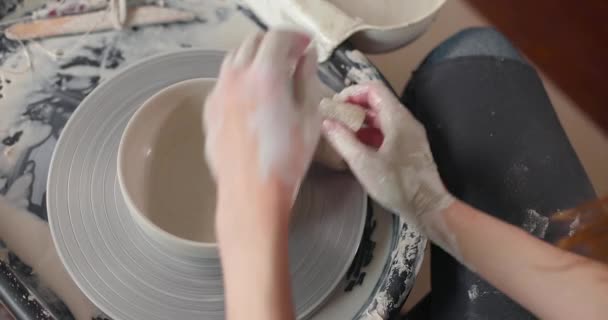 Conceito de cerâmica artesanal. Close-up de mãos de mulheres em estúdio de cerâmica. Vista superior. Movimento lento — Vídeo de Stock