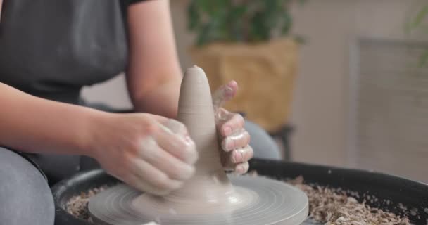 Close-up da mão de um mestre oleiro trabalhando em uma roda de oleiros, formando uma tigela de argila. Movimento lento — Vídeo de Stock