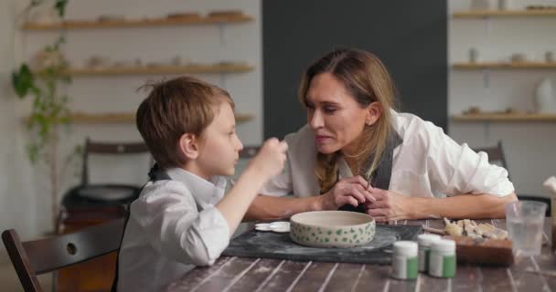 Kid en mam brengen tijd samen door met creatief werk. Kind jongen kust moeder. Langzame beweging — Stockvideo