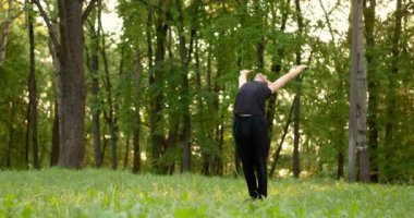 Genç adam sabahları parkta yoga dersi alıyor. Yavaş çekim