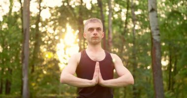 Katlanmış avuç içlerini kapatın erkekler sabah parkta meditasyon yaparlar. Gün doğumunda yoga antrenmanı. Yavaş çekim