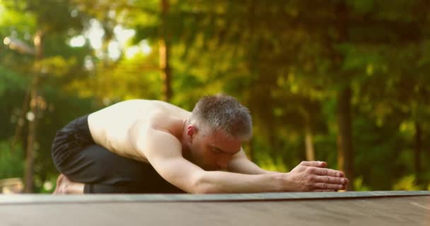 Homem praticando yoga.Yogi snading em joelhos com as mãos esticadas na frente.Guy cabeça em movimento para cima e para baixo — Vídeo de Stock