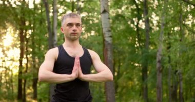 Katlanmış avuç içlerini kapatın erkekler sabah parkta meditasyon yaparlar. Gün doğumunda yoga antrenmanı.