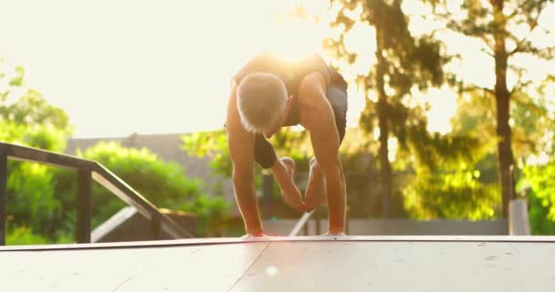 Człowiek robi stojak na rękach w pięknym parku słonecznym.Yogi balansowanie na rękach z nogami w górę iw dół — Wideo stockowe