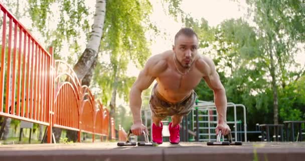 Sportsman doing push-ups exercise at outdoor gym.Shirtless man practicing push-ups in sunny morning — ストック動画