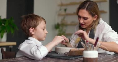 Çömlek sınıfı atölyesi. Anne ve çocuk birlikte yaratıcı işler yaparak vakit geçiriyorlar. Yavaş çekim