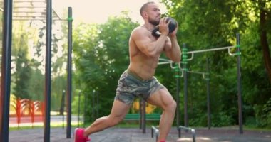 Spor sahasında kettlebell ağırlığıyla çömelmiş bir sporcu. Spor ve sağlıklı yaşam tarzı kavramı. Yavaş çekim