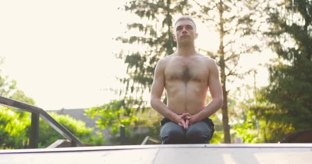 Homem praticando ioga ao ar livre pela manhã.Yogi sentado no tapete de ioga e meditando — Vídeo de Stock