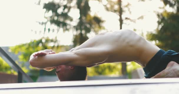 Мужчина практикует йогу асана в городском парке. Йоги выполняет позу с поднятой шеей, грудью и выгнутым позвоночником. — стоковое видео