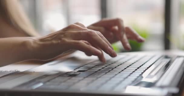 Großaufnahme der Hände einer Geschäftsfrau, die auf der Tastatur ihres Laptops tippt. Freelancer arbeitet online im Café — Stockvideo