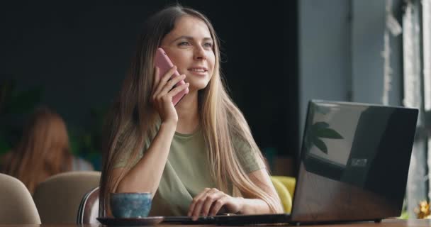 Destul de femeie de afaceri stând în cafenea lângă fereastră vorbind pe telefonul mobil și râzând — Videoclip de stoc
