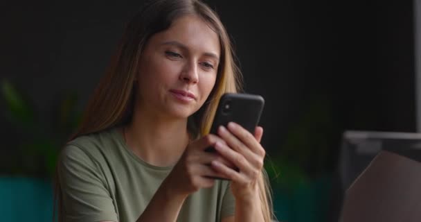 Πορτρέτο της νεαρής γυναίκας που χρησιμοποιεί smartphone και στέλνει μηνύματα κειμένου ενώ ξεκουράζεται σε ζεστό καφέ — Αρχείο Βίντεο