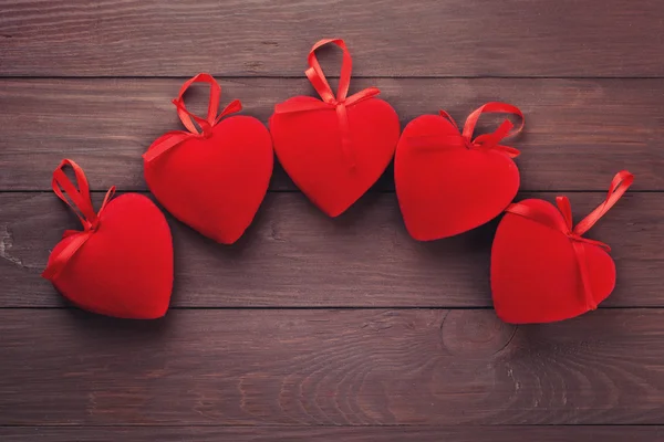 Corazones rojos sobre fondo de madera — Foto de Stock