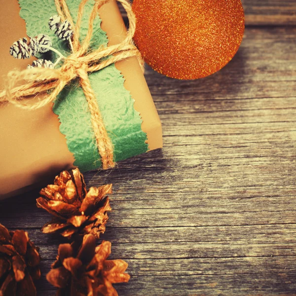 Gift box and pine cones on wooden table — Stock Photo, Image