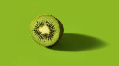 Stüdyoda yeşil arka planda yarım kivi meyvesi. Yarıya bölünmüş kivi meyvesi, doku.