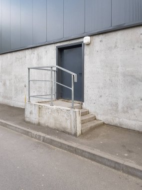 Ön cephedeki kapı, binanın beton duvarı, teknik ya da yangın çıkışı, yükleme alanı