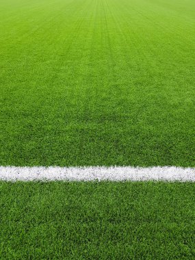 Bir futbol sahasının beyaz çizgili, kaynaklı ya da duvar kağıtlı yapay çimenli bir parçası.