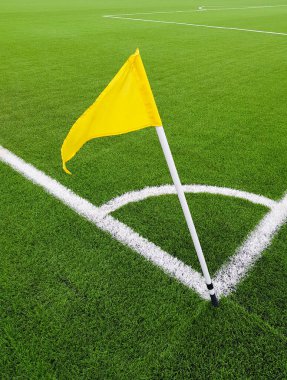 Futbol sahasının köşesindeki sarı bayrak. Futbol topuna köşe vuruşu yapmak için uygun bir yer. Futbolcular için beyaz çizgi işaretleme sahası.