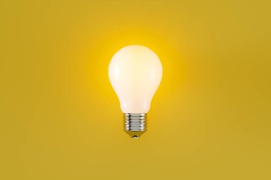 Sarı arkaplanda filamanlı parıldayan klasik ampul, web pankartı ya da şablon, 3D görüntüleme