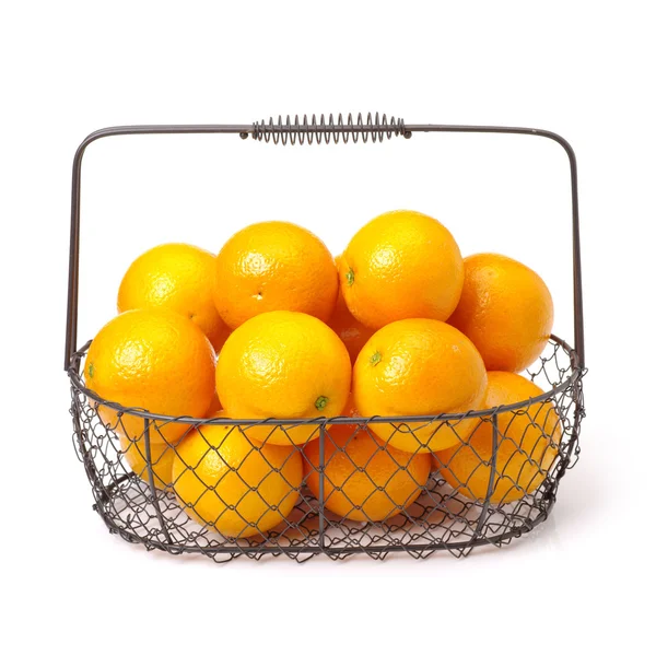 Ripe oranges in iron basket — Stock Photo, Image