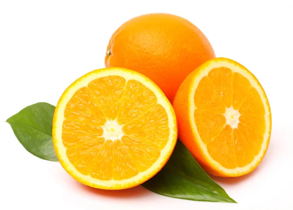 Frische saftige Orangen mit Blättern — Stockfoto