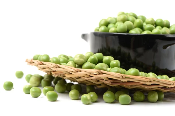 Green pea seeds in black bowl — Stock Photo, Image