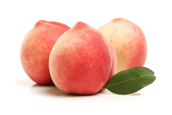 Pile of fresh peaches with green leaf — Stock Photo, Image