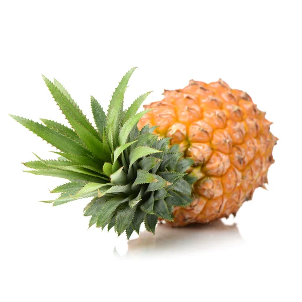 Kokonainen ananas vihreillä lehdillä — kuvapankkivalokuva