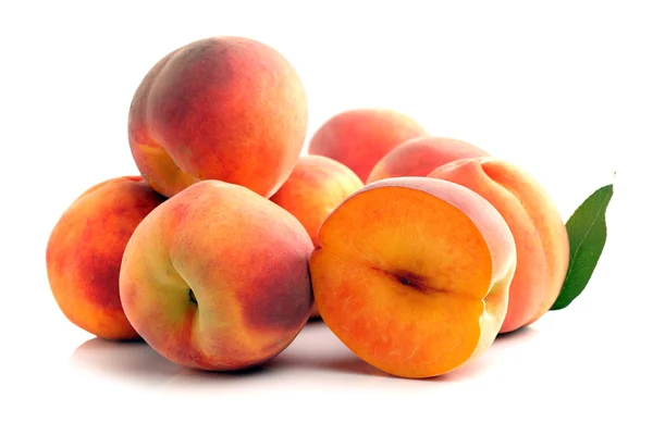 Pile of whole and sliced peaches — Stock Photo, Image