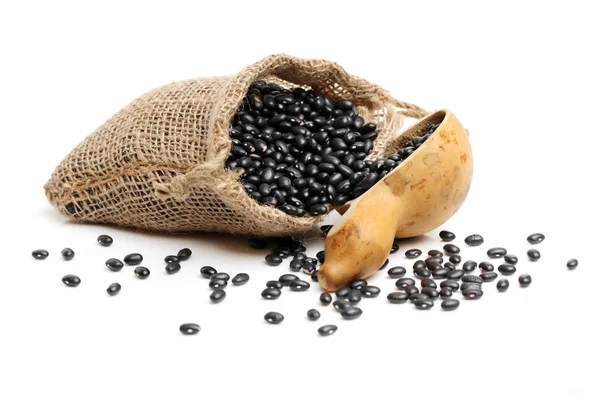 Frijoles negros en bolsa con cuchara de madera — Foto de Stock