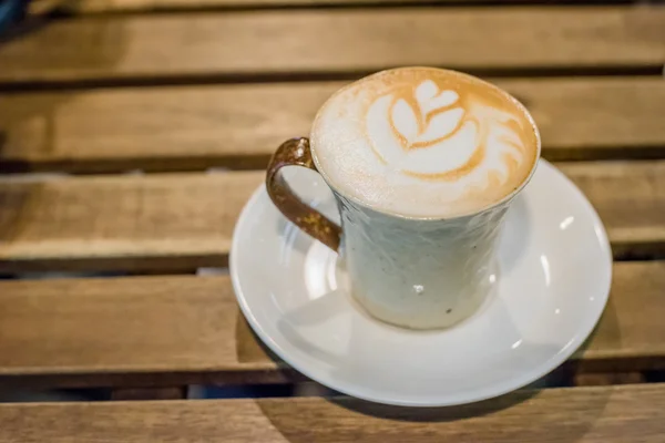 Šálek kávy latte art na dřevo stůl — Stock fotografie