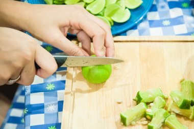 Limon dilimi ahşap tahta üzerinde elinde bıçak ile
