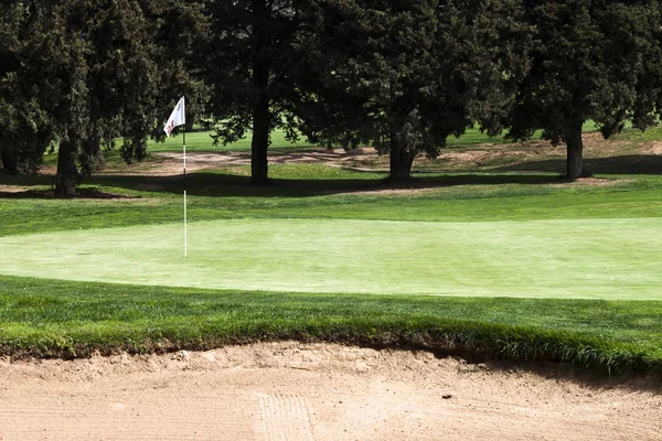 15 th gat flagstick op een putting green in een golfbaan. — Stockfoto