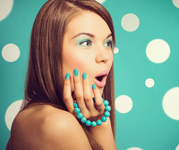 Young beautiful surprised woman holding a turquoise bracelet — Stock Photo, Image