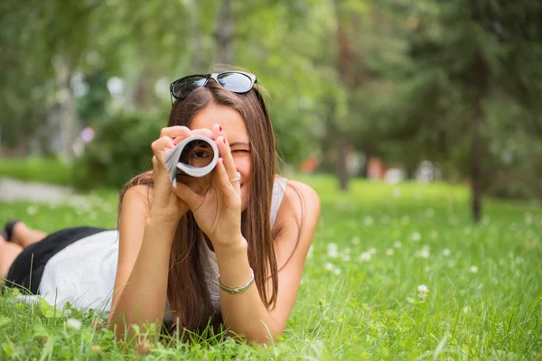Giovane donna bruna godendo la menzogna sull'erba verde in th — Foto Stock