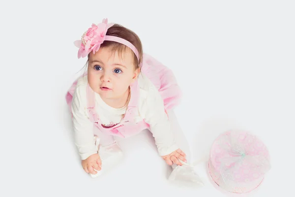 Babymeisje, zittend op de vloer met de doos van de gift en opzoeken — Stockfoto