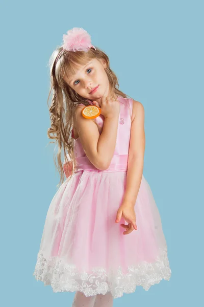 Malá holčička pózuje v ateliéru nad barvou pozadí. Drží — Stock fotografie